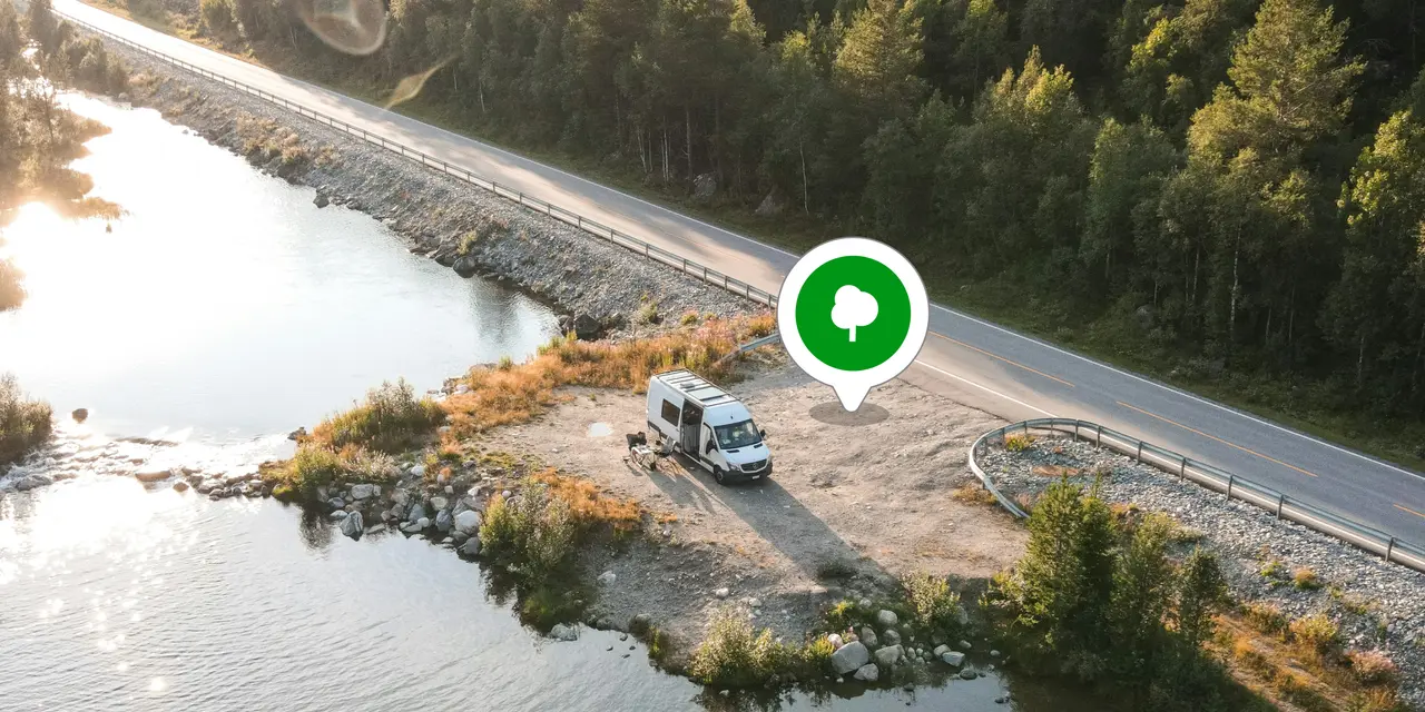 A campervan stopped beside a lake road with a Campa location pin